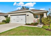 Inviting single-story home with a neatly manicured lawn, quaint front porch seating, and a convenient two-car garage at 3664 Zephyr Preserve Pl, Zephyrhills, FL 33541