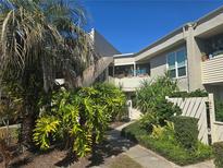 Inviting condo exterior showcasing lush landscaping, a walkway and a charming facade at 423 Windrush Bay Dr, Tarpon Springs, FL 34689