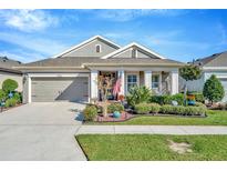 Charming single-story home featuring a manicured lawn, complemented by tasteful landscaping and an attached two-car garage at 7426 Sungold Meadow Ct, Apollo Beach, FL 33572