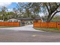 Charming single-story home with an orange horizontal slat fence and a concrete driveway at 934 W Wheeler Rd, Brandon, FL 33510