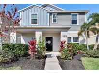 Charming two-story home with a beautifully landscaped front yard and inviting entryway at 12818 Crested Iris Way, Riverview, FL 33579