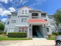 Three story condo building with a red tile roof, balconies, stairs and well maintained landscaping at 18001 Richmond Place Dr # 222, Tampa, FL 33647