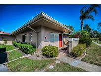 Charming one-story home with neatly landscaped yard, featuring an inviting red front door at 2492 Laurelwood Dr # E, Clearwater, FL 33763