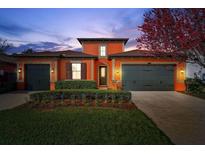 Charming two-story home features a well-manicured lawn, colorful bushes and a two-car garage at 4303 Ortona Ln, Wesley Chapel, FL 33543