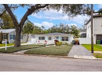 Charming single-story home with light blue shutters, white picket fence and a well-maintained front yard at 4310 W San Luis St, Tampa, FL 33629