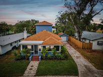 Charming two-story home showcases a well-manicured lawn, lush landscaping, and a detached garage at 605 12Th N Ave, St Petersburg, FL 33701