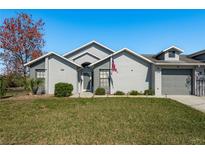 Charming home featuring a well-manicured lawn, neutral paint, manicured landscaping, and an attached one-car garage at 7536 Roland Ct, New Port Richey, FL 34654