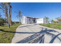 Stunning home with a large driveway, lush landscaping, and a bright white exterior at 809 59Th Ave, St Pete Beach, FL 33706