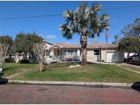 Charming single-story home with a well-manicured lawn, a lovely palm tree, and a convenient access ramp at 903 W Plymouth St, Tampa, FL 33603