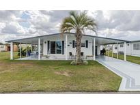 Charming home with a well-manicured lawn, covered parking, and front porch for outdoor living at 36806 Niles Dr, Zephyrhills, FL 33542