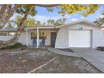 Charming single-story home with a textured stone accent wall, covered porch, and a well-manicured front yard at 4077 Ramona Dr, Spring Hill, FL 34606