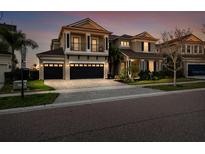 Beautiful two-story home with three-car garage and dark trim, featuring a well-maintained front yard at 6326 Brevada Ln, Apollo Beach, FL 33572