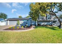 Charming home with a manicured lawn, unique landscaping, and a screened-in pool area at 7115 Edenwood Pl, Tampa, FL 33615