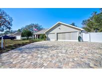 Charming single-story home features a brick-paved driveway and a spacious two-car garage with a neutral color palette at 13255 Don Loop, Spring Hill, FL 34609