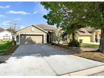 Charming single-story home featuring a two-car garage, neutral stucco, and mature trees in a landscaped yard at 305 Taxter Run Ln, Valrico, FL 33594