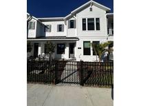 Charming two-story home with white siding, black trim, and well-manicured landscaping at 7225 Sutton Ln, Sarasota, FL 34240