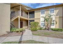 Inviting exterior of a two-story condo building with a well-maintained landscape and staircase at 10195 Sailwinds N Blvd # 101, Largo, FL 33773