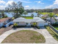 Charming single-story home with a circular driveway and lake view at 1230 75Th N Ave, St Petersburg, FL 33702