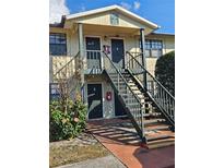 Exterior front view of a two-story building with black stairs, doors, and window trim at 12413 Oak Cedar Pl # 201, Tampa, FL 33612