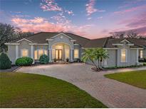 Beautiful single-story home with a tile roof, brick driveway and lush landscaping at 13854 Thoroughbred Dr, Dade City, FL 33525