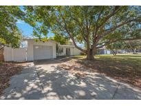 Charming single-story home featuring a spacious front yard and a private driveway with an attached garage at 1937 Palm Dr, Clearwater, FL 33763