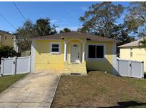 Charming yellow home with a well-manicured lawn and freshly painted white trim at 7411 S Elliott St, Tampa, FL 33616