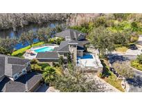 Stunning aerial view of waterfront home with pool and roof deck at 7425 Terrace River Dr, Temple Terrace, FL 33637