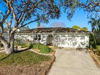 Charming home with a two-car garage, a well-manicured lawn, and mature trees providing shade at 8083 Bayhaven Dr, Seminole, FL 33776