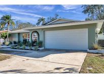 A side view of the home's exterior showing the two-car garage and manicured landscaping at 13330 88Th Pl, Seminole, FL 33776