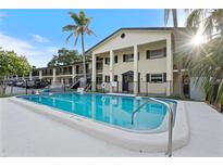 Exterior view featuring a community pool with clear blue water surrounded by a well-maintained building at 2 N Fernwood Ave # 33, Clearwater, FL 33765