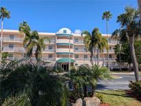 Stunning exterior view of a condo building with lush palm trees and landscaping at 6315 Shoreline Dr # 3305, Madeira Beach, FL 33708