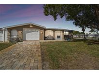 Charming home featuring a paved driveway, well-maintained lawn and mature tree providing nice curb appeal at 9201 Lunar Ln, Port Richey, FL 34668