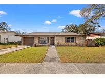 Charming single-story home featuring a stone facade, well-maintained lawn, and a cozy front porch with bench at 1314 Oak Valley Dr, Seffner, FL 33584