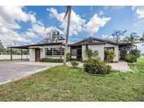 Charming single-story home featuring a carport, a lush front lawn, and mature landscaping at 2050 W Bearss Ave, Tampa, FL 33618