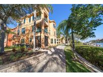 Elegant building exterior featuring balconies, lush landscaping, and a walkway leading to waterfront views at 2717 Via Cipriani # 614B, Clearwater, FL 33764