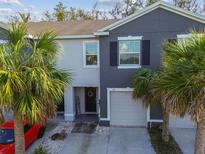 Two-story townhome showcasing a one-car garage, neutral color scheme and complemented by lush palm trees at 3313 Pleasant Willow Ct, Brandon, FL 33511