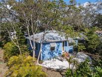 Charming blue cottage with metal roof, mature trees and a gravel patio area at 4921 24Th S Ave, Gulfport, FL 33707