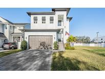 Two story home with a large garage and a neatly kept lawn and an American flag hanging at 619 Danube Ave, Tampa, FL 33606