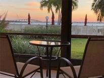 View from balcony with table and chairs, facing the bridge, water, and sunset at 6365 Bahia Del Mar Blvd # 112, St Petersburg, FL 33715