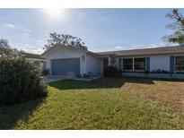 Charming single-story home featuring a well-maintained lawn and attached garage at 1091 Mcfarland St, Dunedin, FL 34698