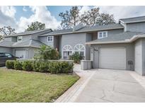 Charming two-story townhome featuring an attached garage and manicured landscaping at 388 Buckingham Pl, Palm Harbor, FL 34684