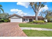 Charming single-story home featuring a manicured lawn and beautiful brick driveway at 4309 Deepwater Ln, Tampa, FL 33615