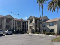 Exterior view of a multistory building, ample parking and lush tropical landscaping with palms at 4515 Whitton Way # 121, New Port Richey, FL 34653