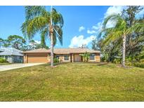 Charming single-story home with a well-manicured lawn and mature palm trees at 5327 N Cranberry Blvd, North Port, FL 34286