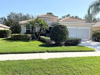 Charming single-story home with a tile roof, manicured lawn, and lush tropical landscaping at 6400 Falcon Lair Dr, North Port, FL 34287