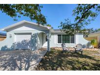 Charming single-story home with a front yard seating area and attached garage at 1413 Wisconsin Ave, Palm Harbor, FL 34683