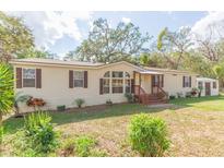 Charming single-story home featuring a covered front porch, neutral siding, and well-maintained landscaping at 36246 Peak St, Zephyrhills, FL 33541