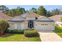 Charming single-story home with a well-manicured lawn, complemented by lush landscaping and a welcoming two-car garage at 4421 Larkenheath Dr, Spring Hill, FL 34609