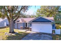 Charming single-story home featuring a two-car garage, stone accents, and a well-maintained front lawn at 8600 Berkley Dr, Hudson, FL 34667