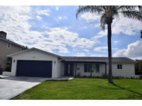 Charming single-story home with a well-manicured lawn and a blue two-car garage door at 1324 51St Ne Ave, St Petersburg, FL 33703